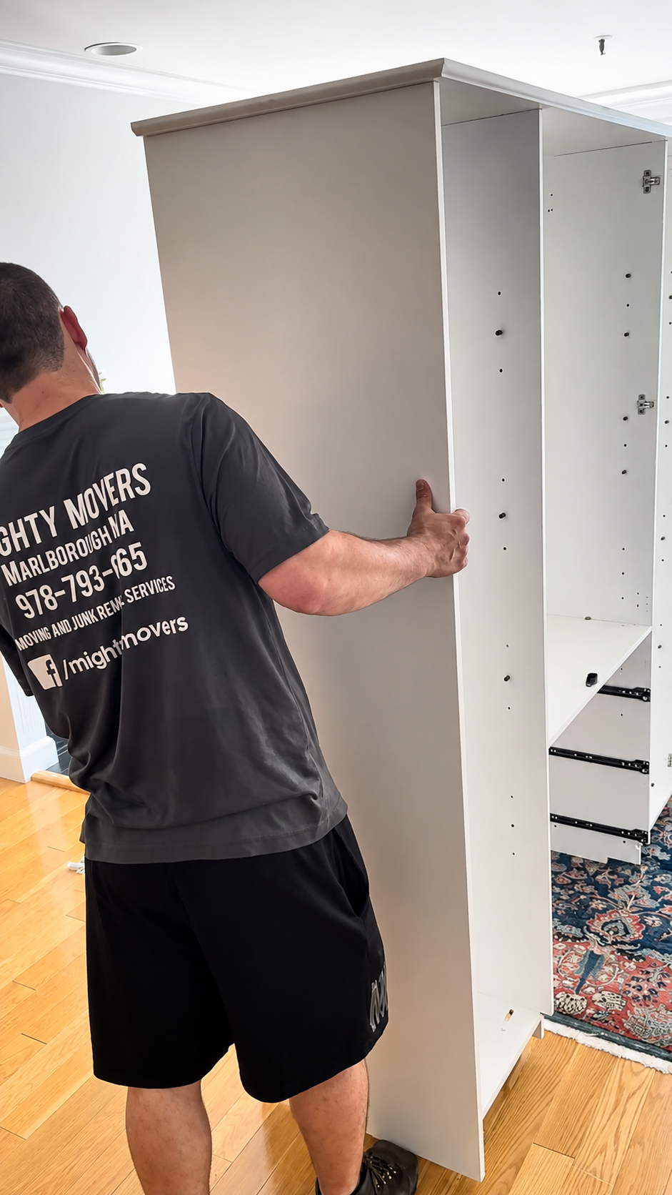 Mighty Movers professional carefully handles a large wardrobe during a residential move in Marlborough, Massachusetts.